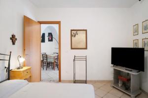 a bedroom with a bed and a flat screen tv at Casa di Lo in Laigueglia