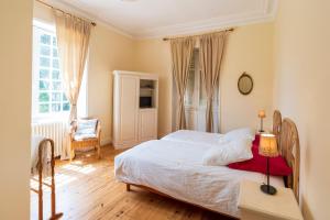 a bedroom with a bed and a table with a lamp at Villa d’Exception, Piscine, Parc in Soustons +30 photos