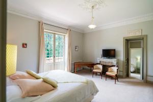 a bedroom with a bed and a desk and a television at Villa d’Exception, Piscine, Parc in Soustons