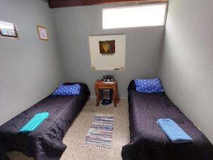 two beds in a room with a window and a table at Casa Manipa -3 dormitorios in Cafayate