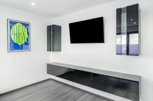 a living room with a tv and two pictures on the wall at Moin, die Ferienwohnung in Wilhelmshaven