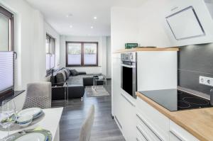 a kitchen and living room with a table and a couch at Moin, die Ferienwohnung in Wilhelmshaven