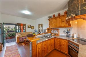 a kitchen with wooden cabinets and a sink at Casa Isabel in Tijarafe