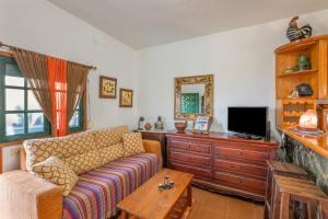 a living room with a couch and a tv at Casa Isabel in Tijarafe