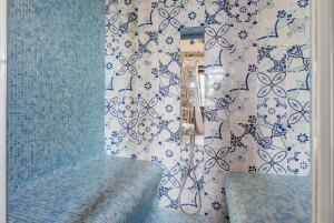 a bathroom with a shower and a bench and a wall at Romantico casale di lusso con Spa in Conca dei Marini +16 photos