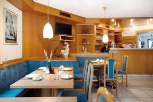 a restaurant with tables and chairs and a kitchen at Pension Waldheim Rooms in San Giacomo