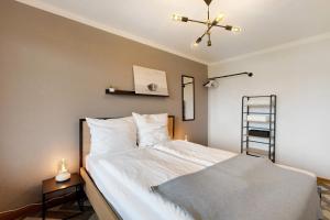 a bedroom with a large white bed with a ceiling fan at Seeluft direkt am Wasser in Reichenau