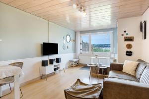 a living room with a couch and a tv at Seeluft direkt am Wasser in Reichenau