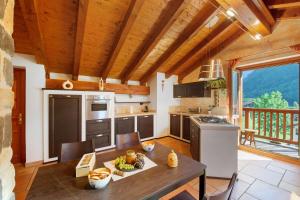 a kitchen with a wooden ceiling and a table with food on it at Anita Haus - Issime in Issime +18 photos
