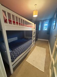 a bedroom with two bunk beds and a rug at Dickens HideAway in Hollington
