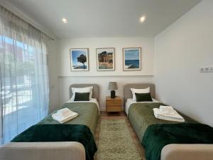 a bedroom with two beds and a window at The Olive Tree Apartment in Tavira +22 photos
