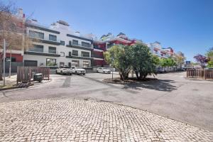 a street with cars parked in a parking lot at The Olive Tree Apartment in Tavira