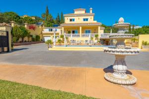a large house with a fountain in the yard at Villa Roca Penthouse in Estepona