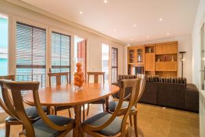 a living room with a wooden table and chairs at Canet Beach 1 in Canet de Mar +11 photos