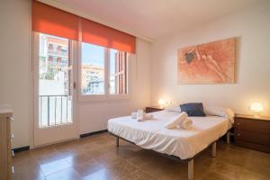 a bedroom with a bed and a large window at Canet Beach 1 in Canet de Mar