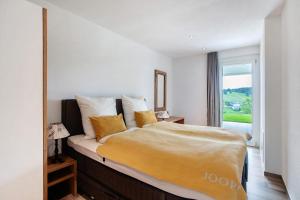 a bedroom with a large bed with a large window at Chalet Foret - Ferienwohnung in Todtnauberg