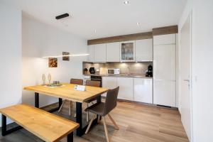 a kitchen and dining room with a wooden table and chairs at Chalet Foret - Ferienwohnung in Todtnauberg