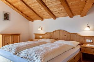 a bedroom with a large bed with wooden ceilings at Haus Alpenblick Apt Edelweiß in Laion