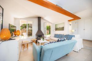 a living room with a blue couch and a fireplace at Can Botana 7 in Cala de Sant Vicenc