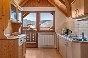 a kitchen with a large window with a view at Haus Alpenblick Apt Edelweiß in Laion