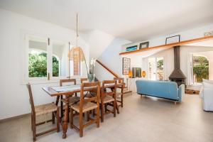 a dining room with a table and a blue couch at Can Botana 7 in Cala de Sant Vicenc