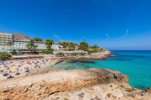 a group of people on a beach near the ocean at Can Botana 7 in Cala de Sant Vicenc