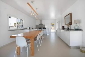 a kitchen and dining room with a wooden table and chairs at Peace House Lourinhã - Villa 8 in Lourinhã