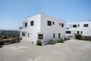 a white building with a lot of plants in front of it at Peace House Lourinhã - Villa 8 in Lourinhã
