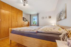 a bedroom with a bed with a wooden cabinet at Weserberglandblumen in Bad Pyrmont