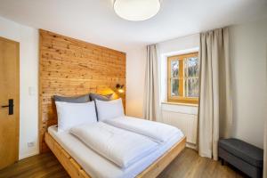 a bedroom with a large white bed with a wooden headboard at Mountain Residence Kasern Nr 1 in Predoi