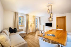 a living room with a table and a couch at Mountain Residence Kasern Nr 1 in Predoi