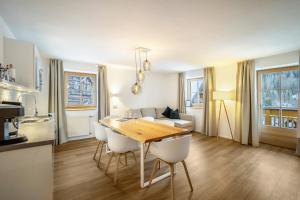 a kitchen and living room with a wooden table and chairs at Mountain Residence Kasern Nr 1 in Predoi