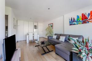a living room with a couch and a tv at Petitbuch in La Teste-de-Buch