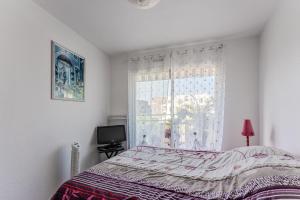 a bedroom with a bed and a window at Petitbuch in La Teste-de-Buch