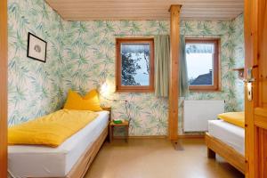 a bedroom with two beds and a wall covered in wallpaper at Ferienhaus am Ried in Ostrach