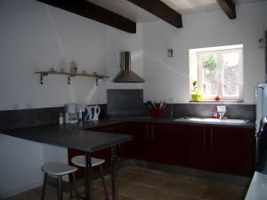 a kitchen with a table and a sink and a window at Gîte Joly in Corseul +6 photos