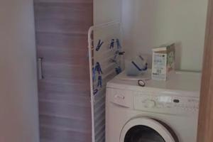 a laundry room with a washing machine in a room at Gîte Joly in Corseul