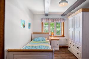 a bedroom with a bed and a desk and a window at Fewo Silke Dethlefsen in Pellworm