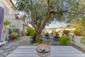 a patio with a table with a tree and chairs at Villa Blu La Cambusa in Castro di Lecce
