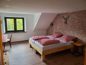 a bedroom with a bed and a brick wall at Bergwiesnblick Apartments in Bärenstein