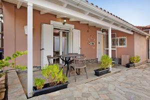 a patio with a table and chairs in front of a house at Villa Dionysia Two-bedroom House in Alikanas