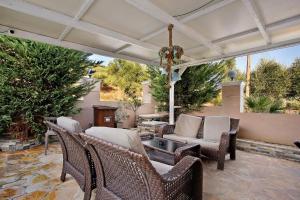 an outdoor patio with wicker chairs and a table at Villa Dionysia Two-bedroom House in Alikanas