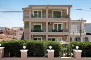 a large house with bushes in front of it at Villa Dionysia Two-bedroom House in Alikanas +5 photos