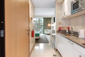 a kitchen with a sink and a living room at Dfm Happy Days E - Funchal in Funchal +8 photos