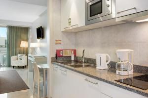 a kitchen with a sink and a microwave at Dfm Happy Days E - Funchal in Funchal