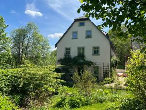 a white house in the middle of a garden at Vorwerk Biensdorf in Lichtenau