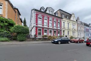 a red and white building with cars parked in front of it at Alte Stadtvilla in Neuwied