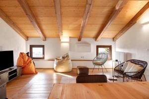 a living room with wooden ceilings and a table and chairs at Vicolo 10 in Asti