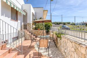 a patio with a table and chairs and an umbrella at Pilella in Alliste