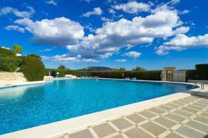 a swimming pool with a blue sky and clouds at Vistas a Moraira in Teulada